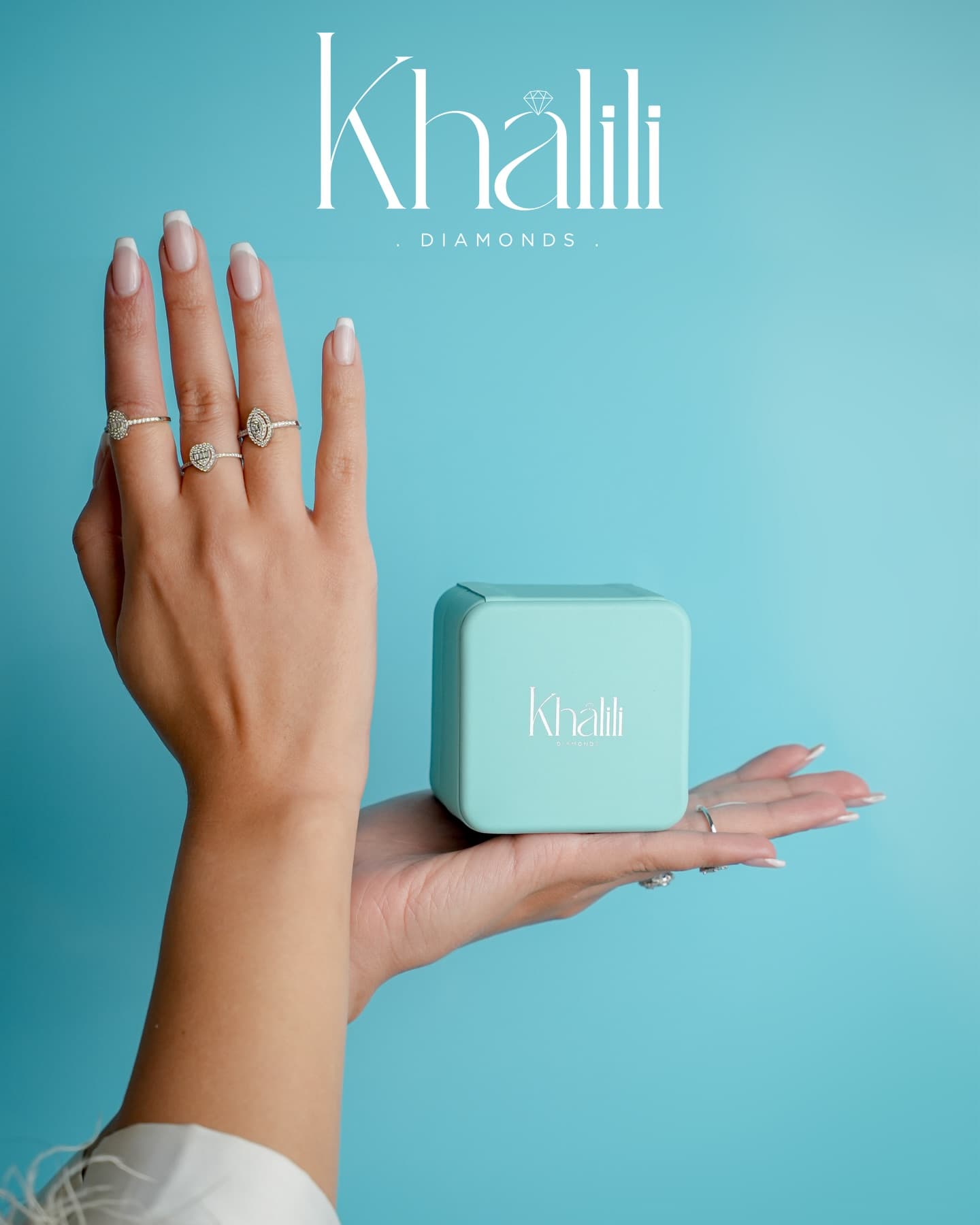 Hand holding a Khalili jewellery box wearing three diamond rings